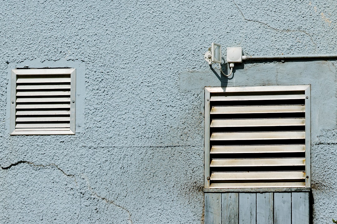 two-vents-are-set-into-a-textured-blue-wall-rzmzb-a28a8